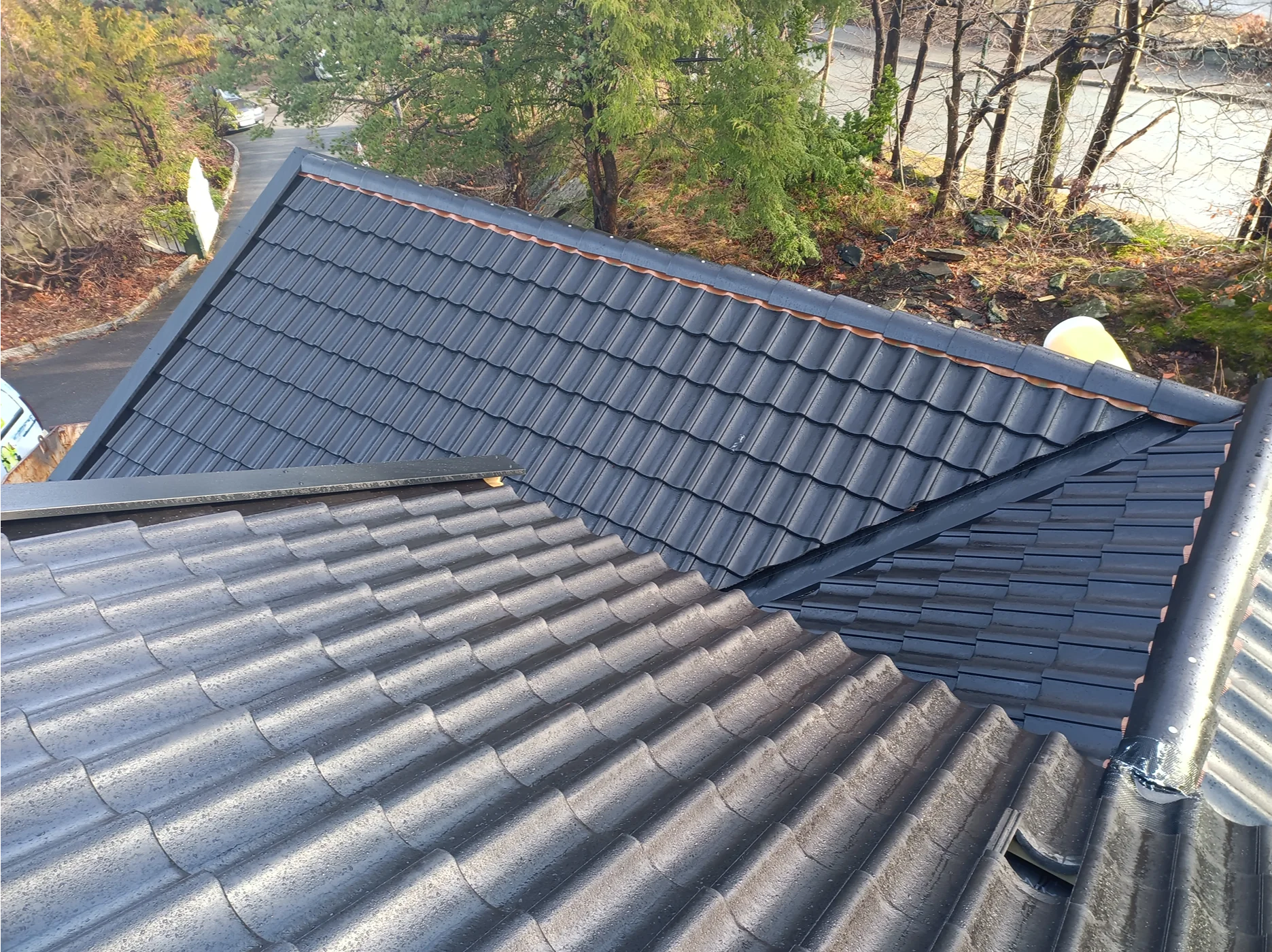 Residential roof renovation with modern metal shingles installed