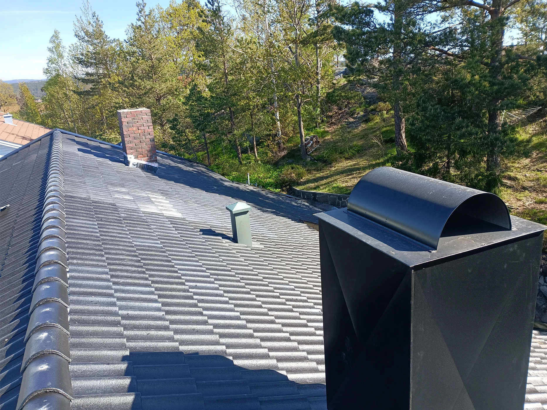 Modern metal roof installation with chimney