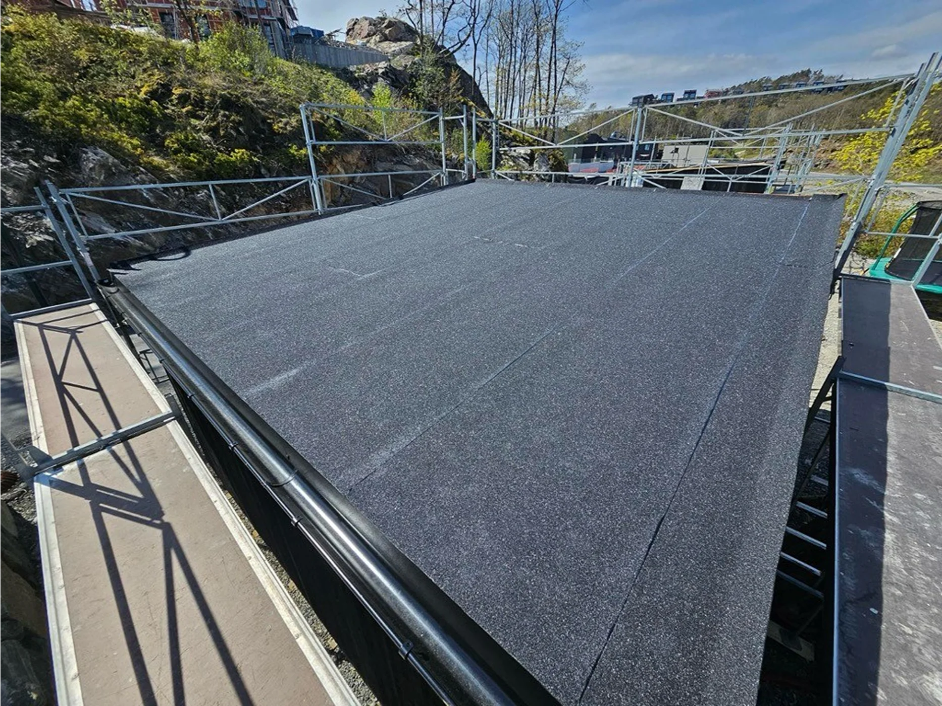 Modern flat roof with dark bitumen membrane installation