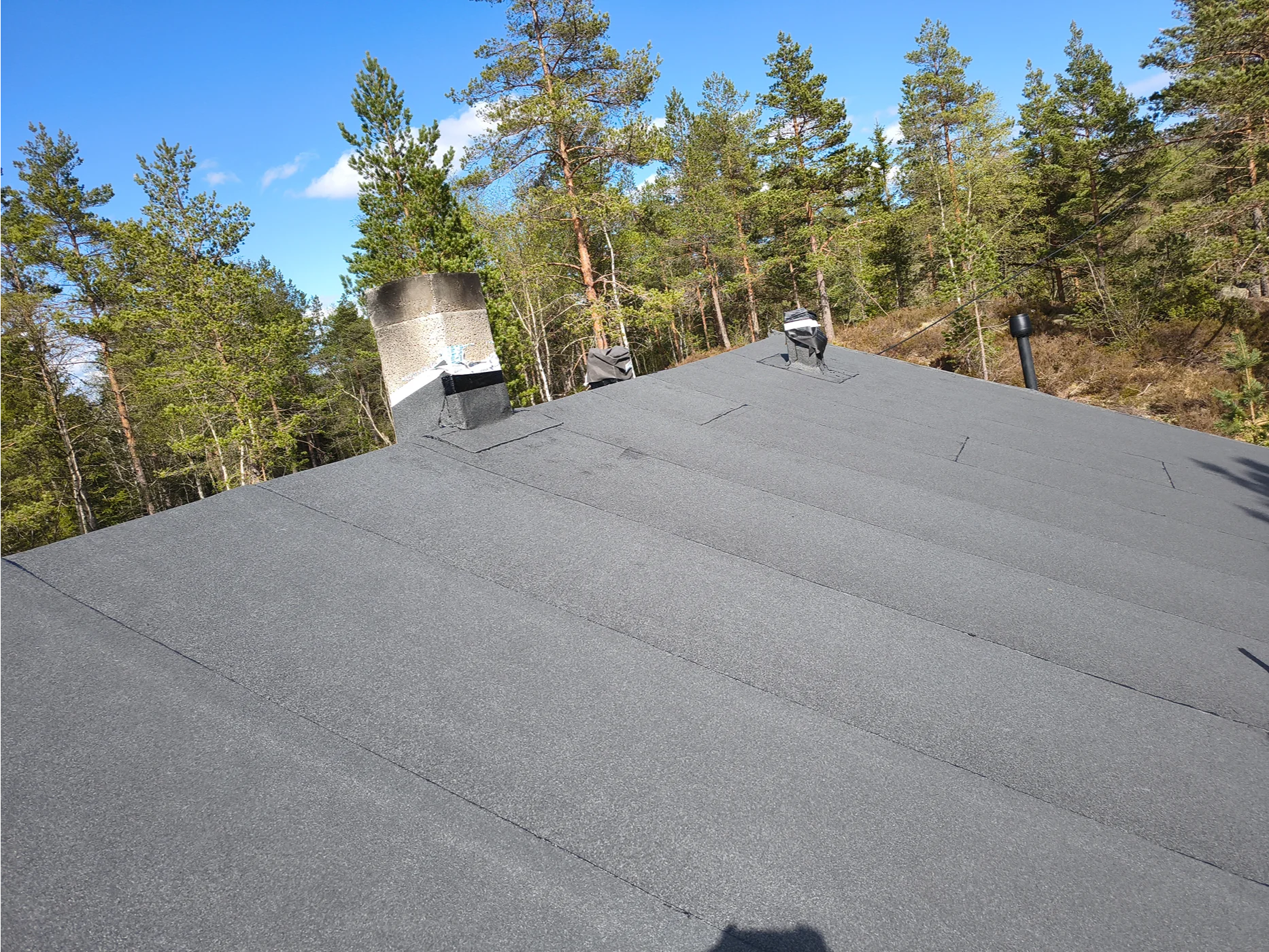 Residential roof shingles installation with forest view