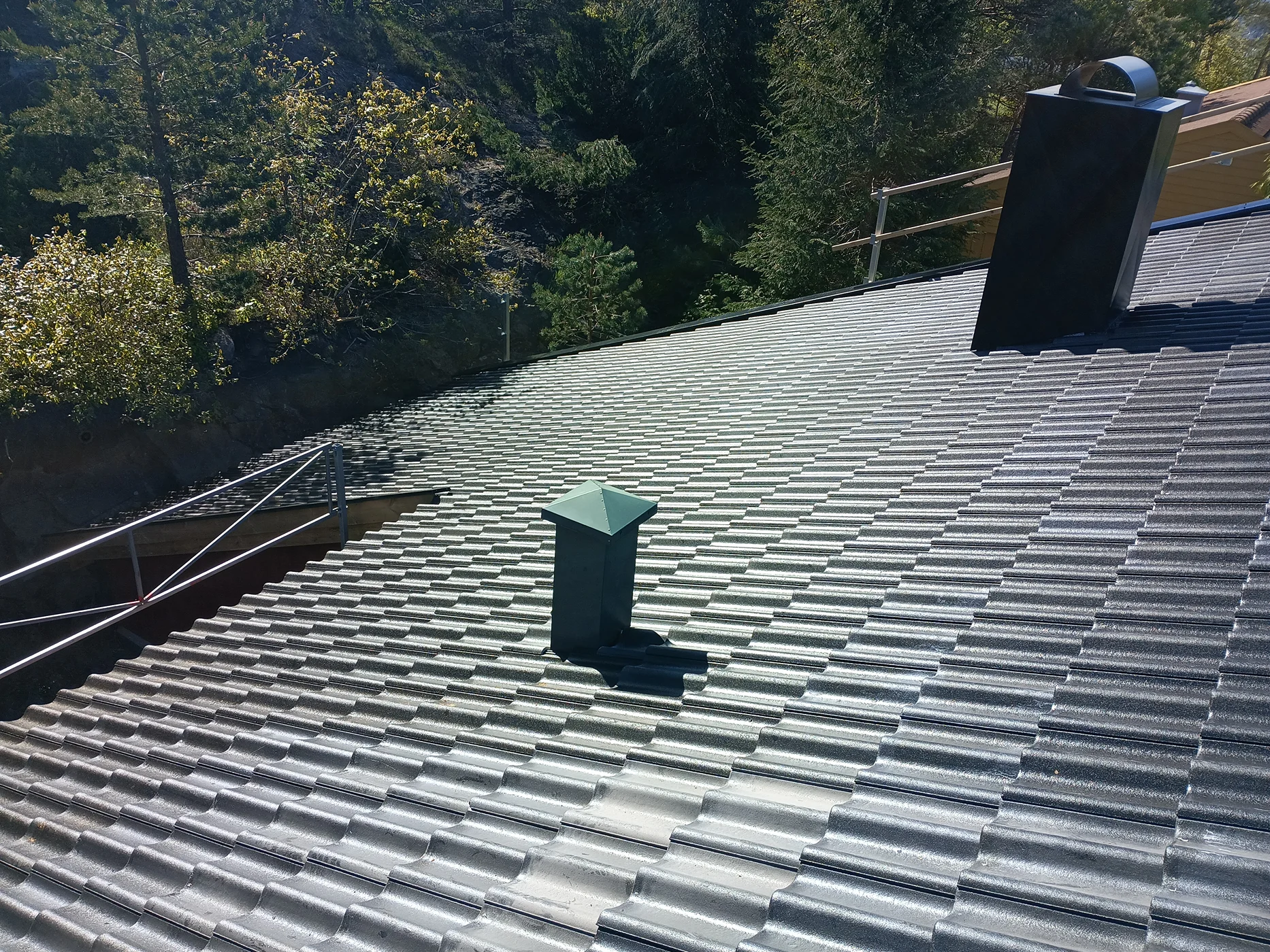 Modern metal roof with green chimney installed