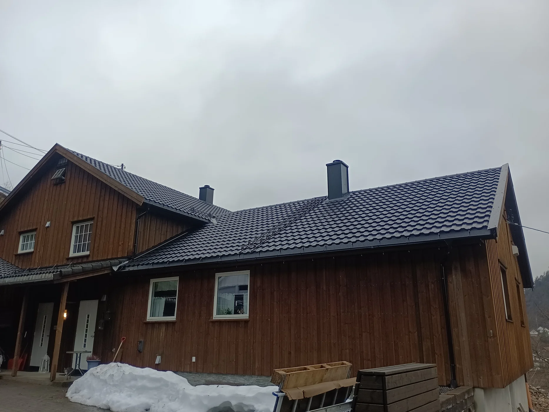 Modern wooden house with dark metal roof