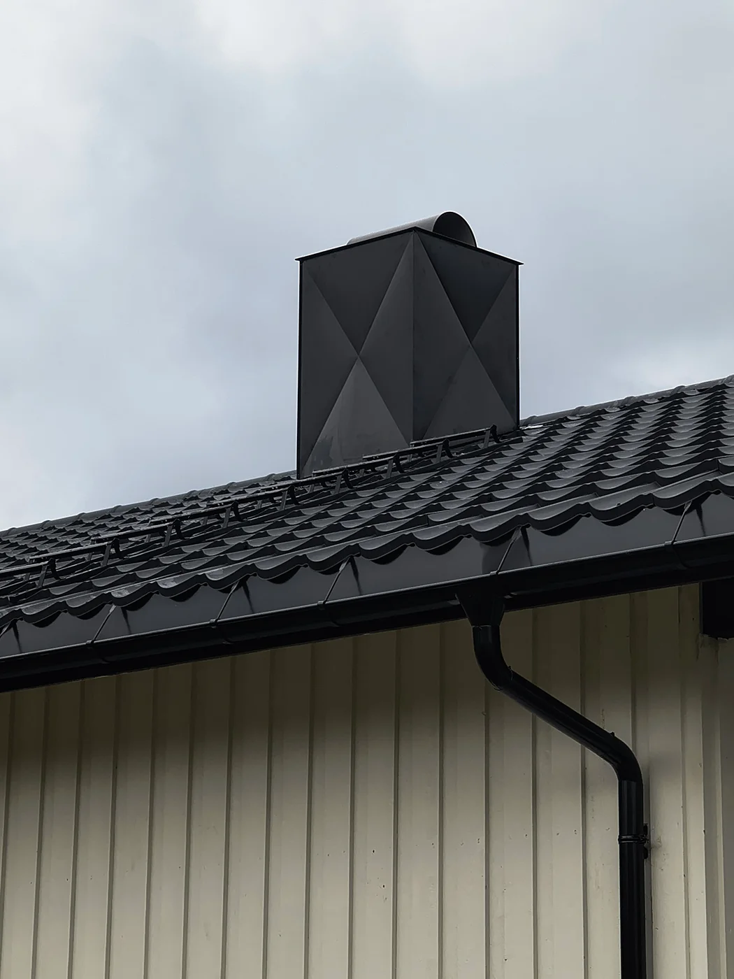Modern black geometric chimney on roof