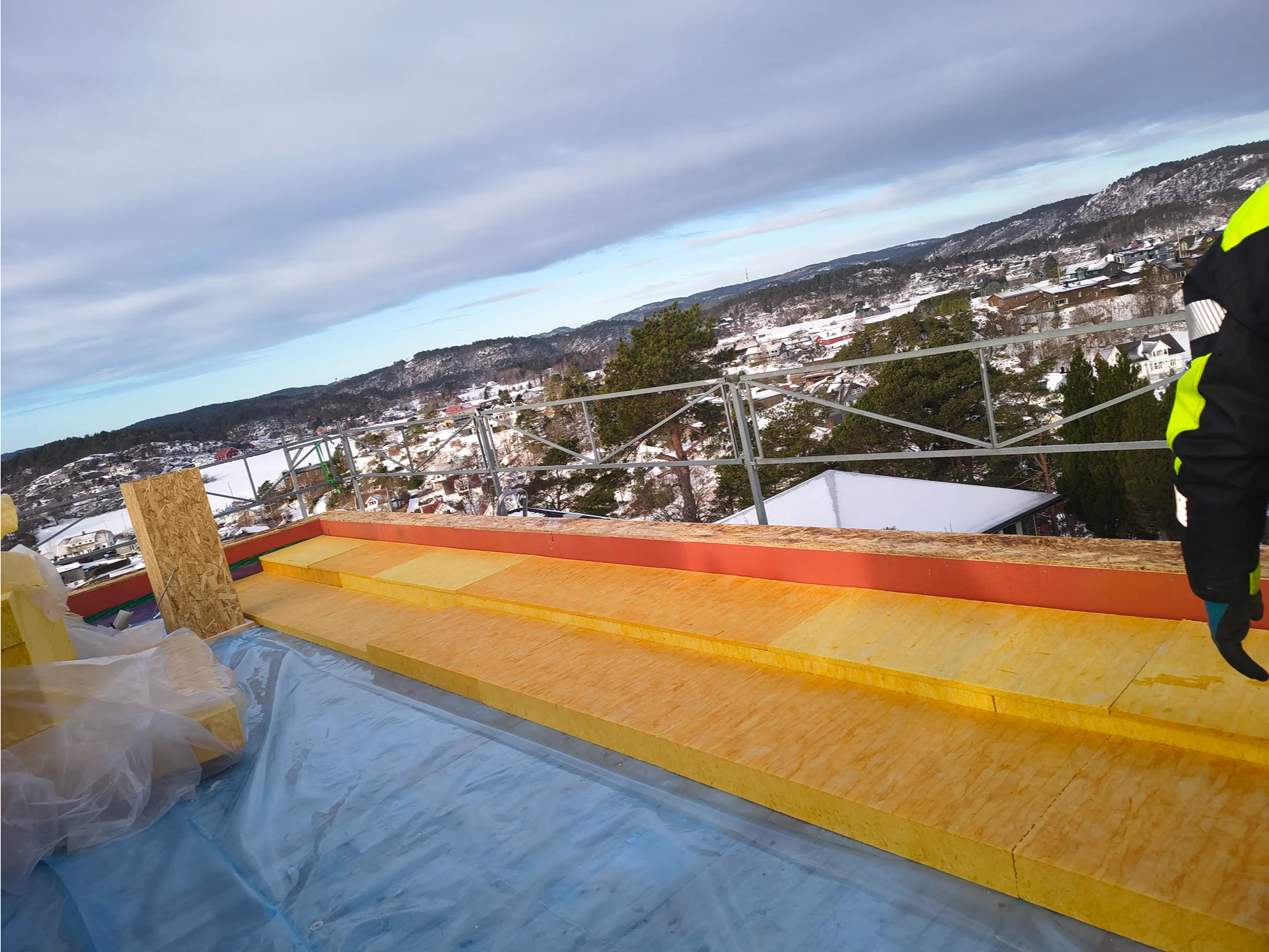 Roofing structure installation overlooking residential landscape