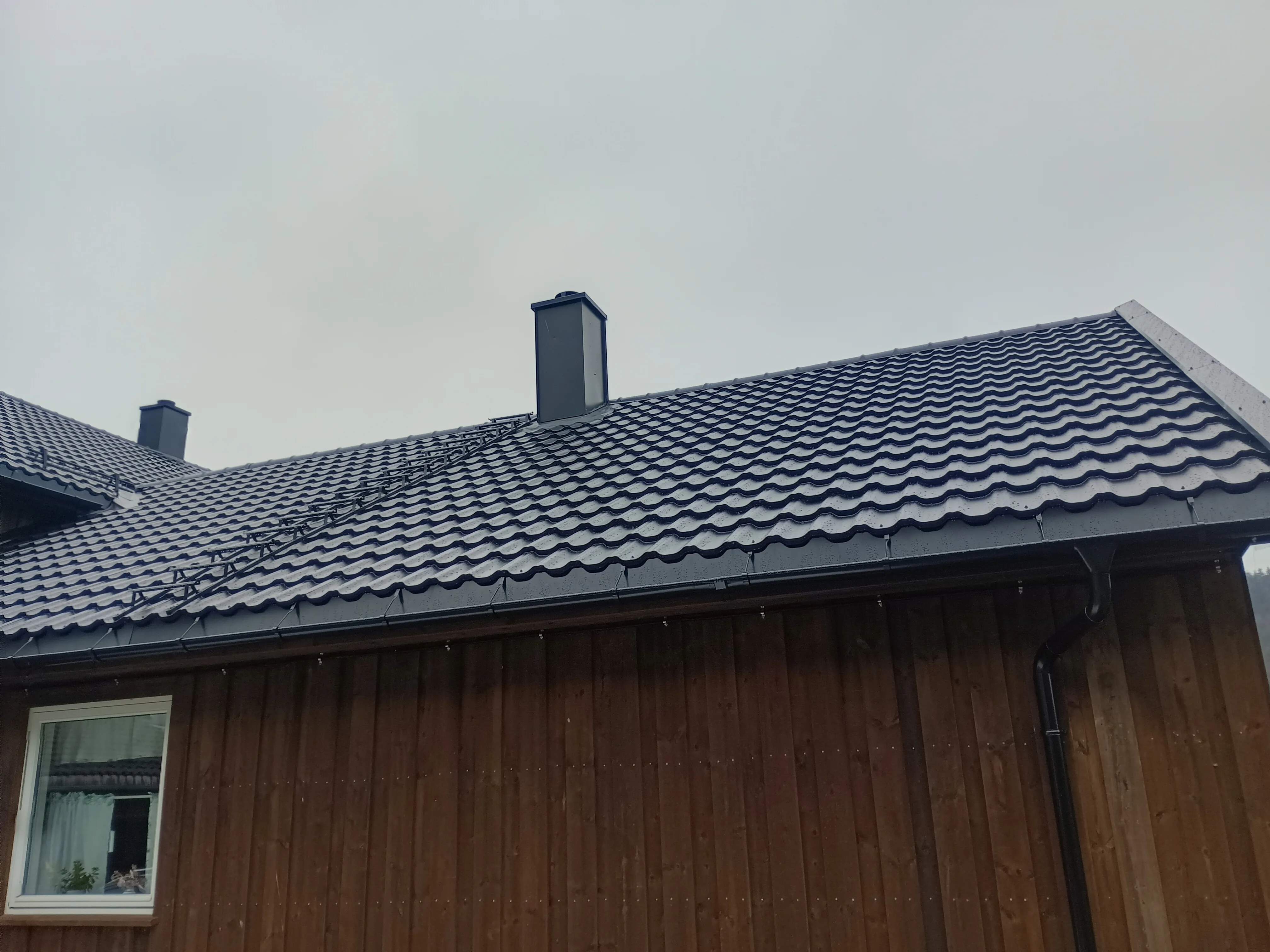 Takstein på skråtak med pipebeslag og trevegger