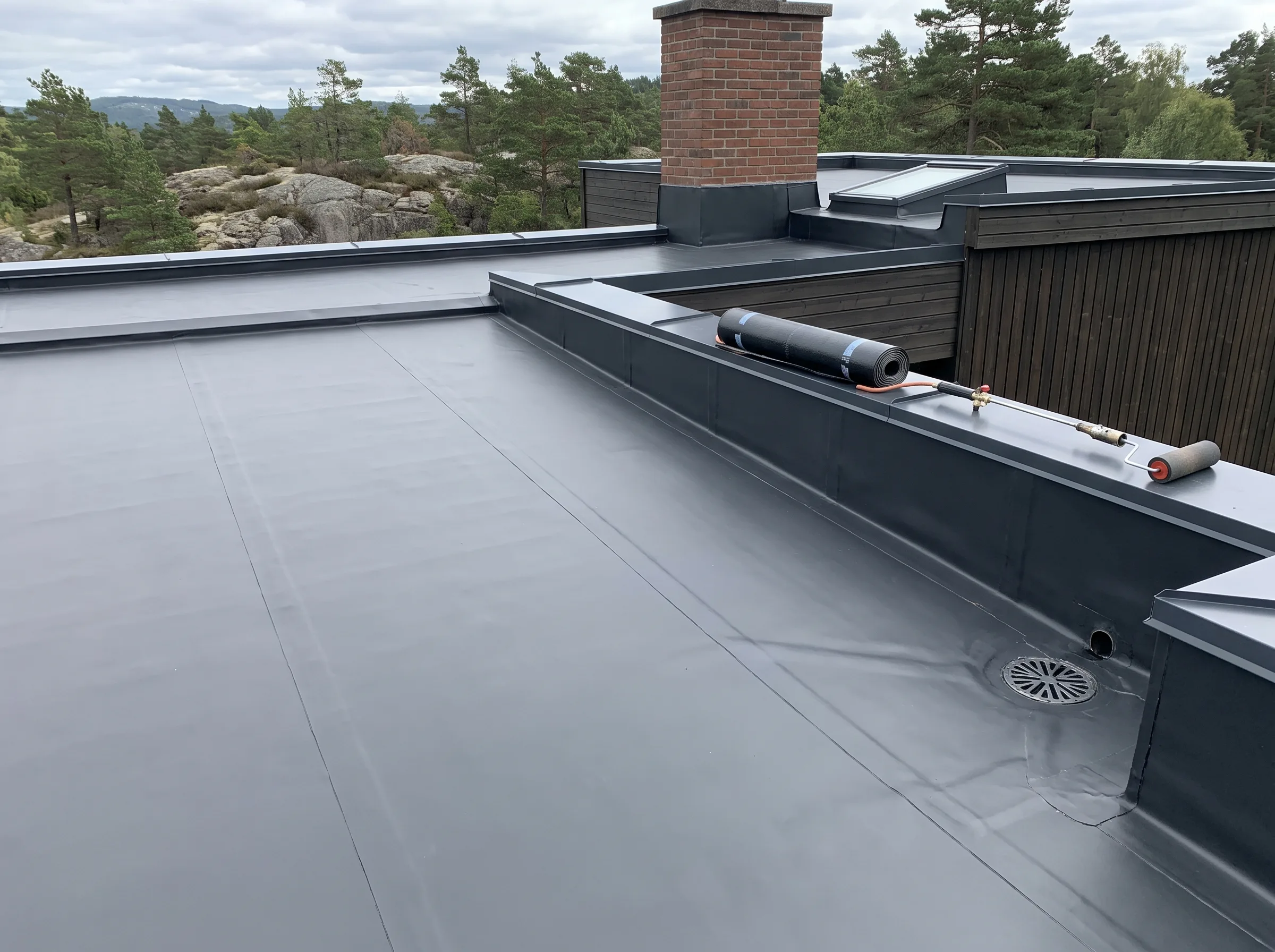 Flatt tak med vanntett membran, detaljer av takrenner og pipeløsning