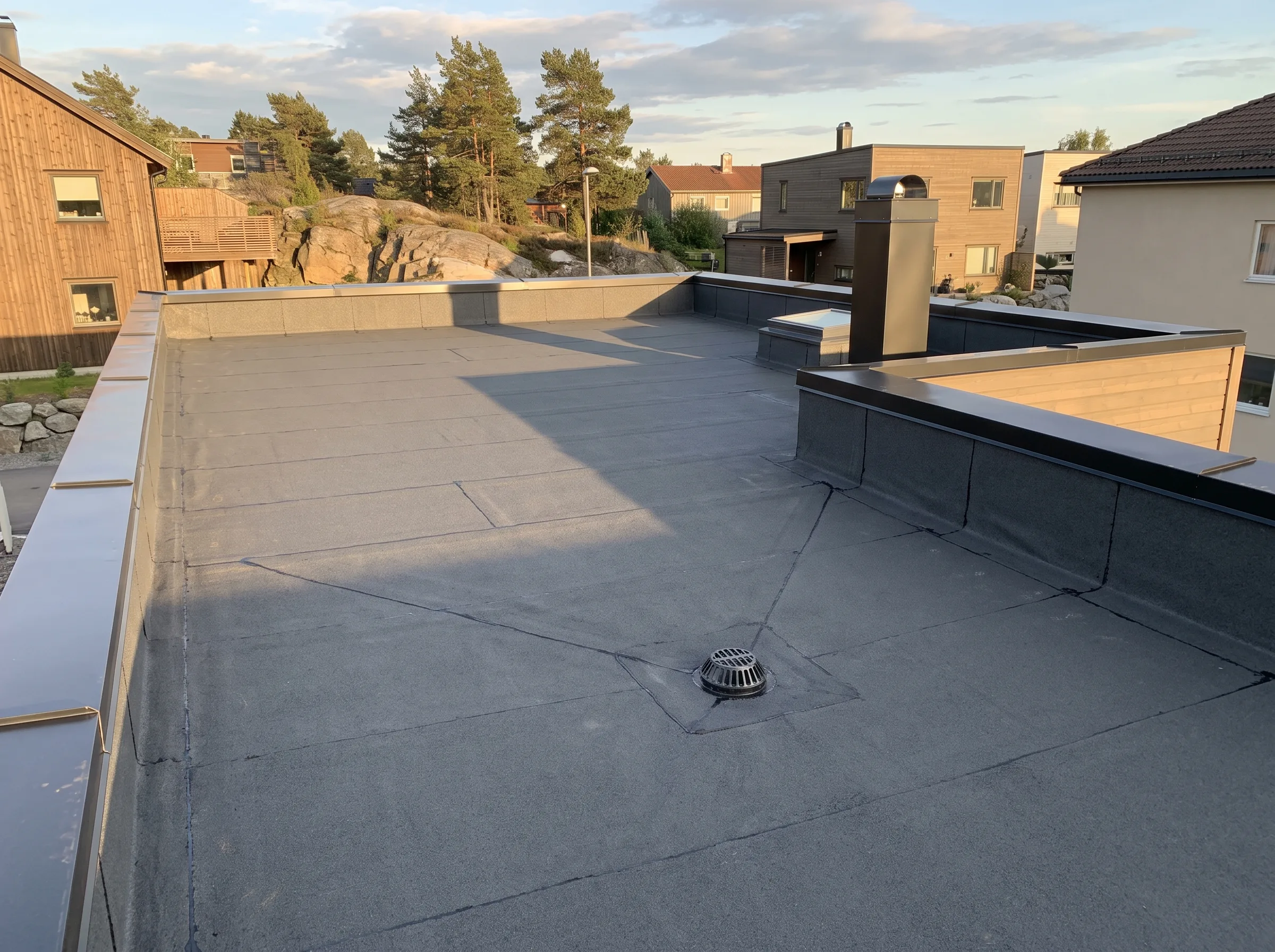 Flatt tak laget av takmembran med ventilasjonssystem og skorstein