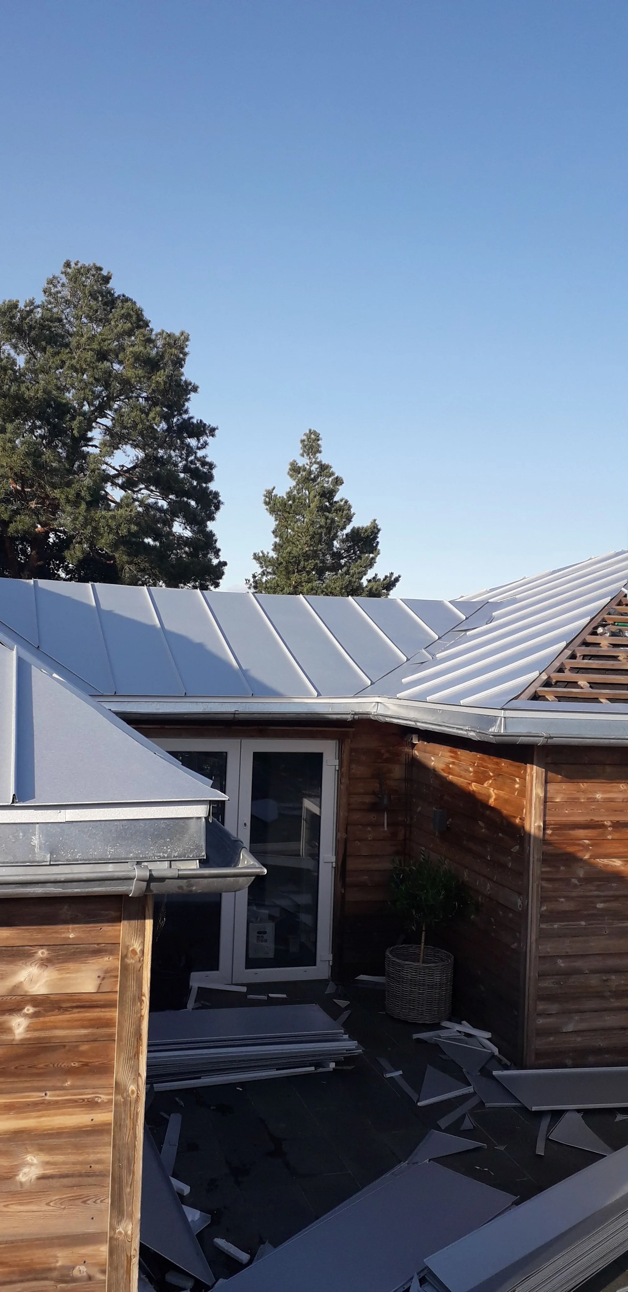 Takonlegging av ståltak med moderne design og solfylt himmel