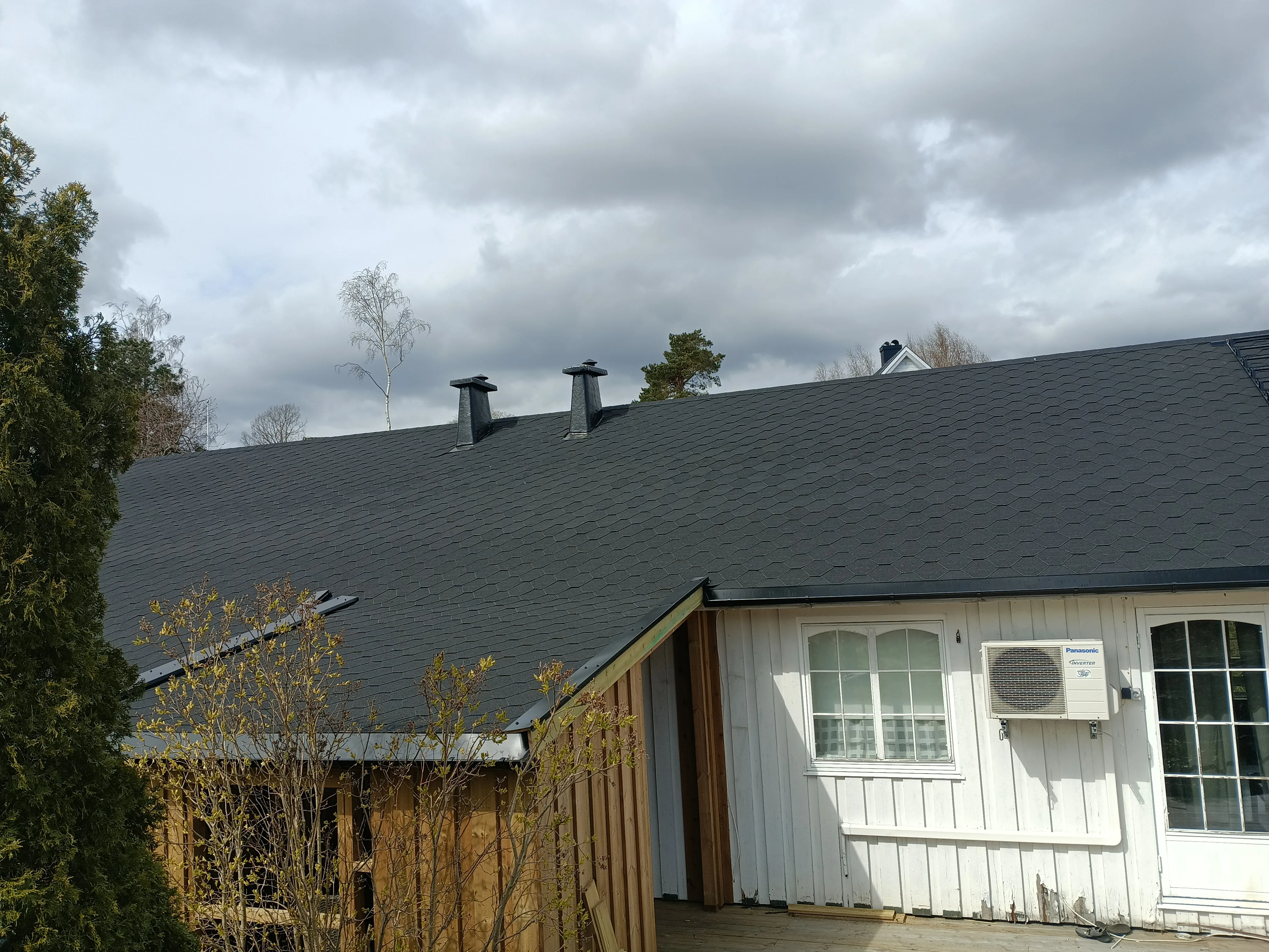 Nytt tak med svart takpapp og rørbeslag på toppen av huset