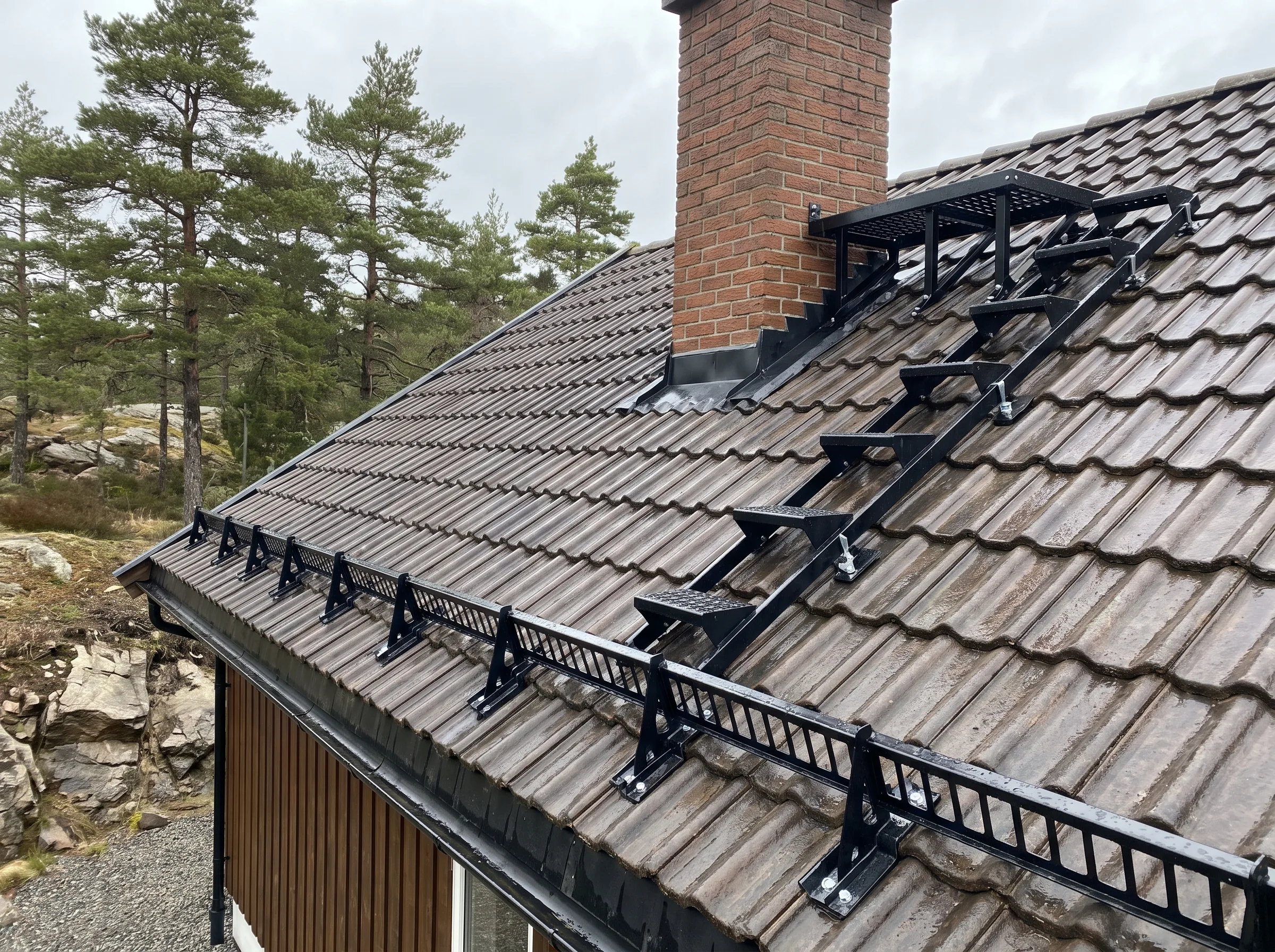 Takstein med snøfangere installert på taket av en hytte